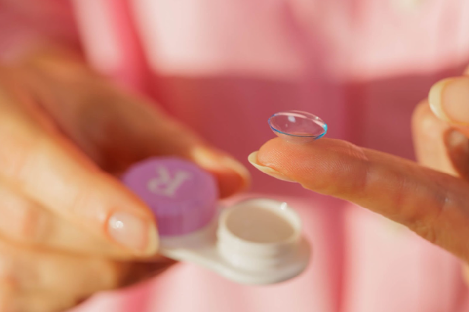 Close-up of a contact lens placed on a fingertip for insertion